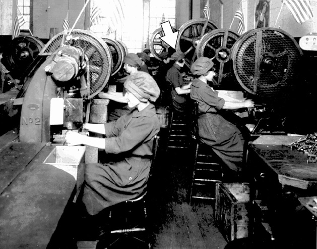 Lorna (arrow) working at a cutting machine on the main floor at Cole & Lord’s Gent’s Accessories, in Chacallit, about 1918. Note flags mounted atop machines at Luther Huber’s suggestion, to remind the women that belt buckles could win the war.

